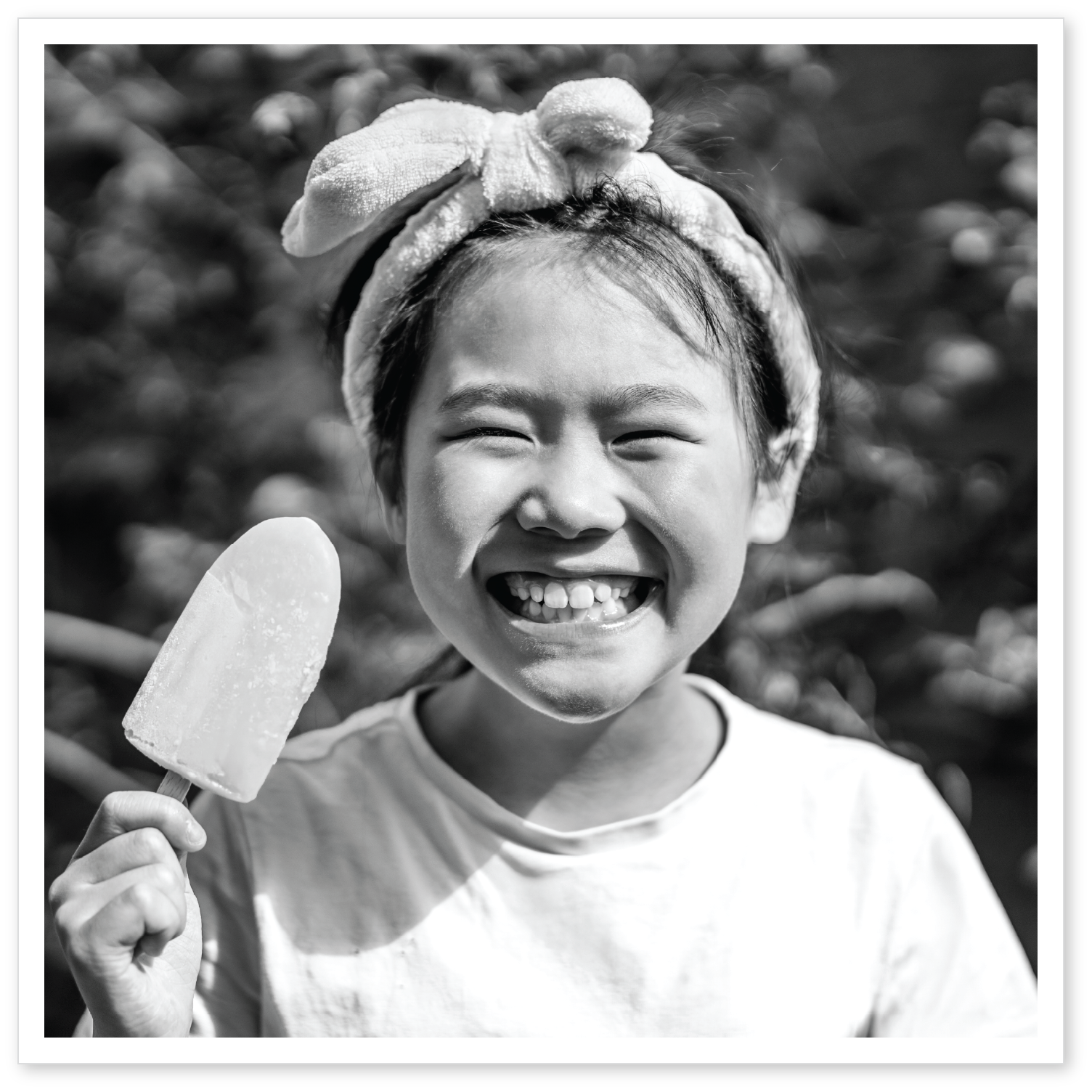 A little girl smiling holding a popcicle A little girl smiling holding a popcicle